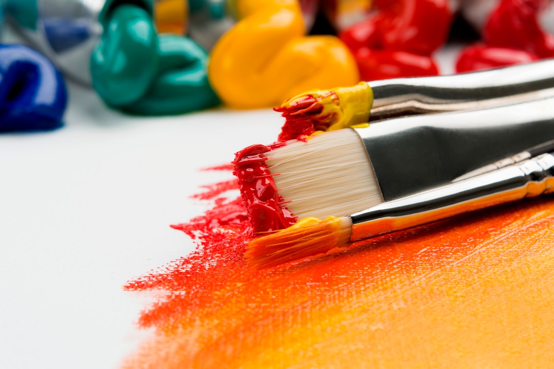 Close-up of paintbrushes with vibrant paint on a canvas.